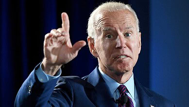 Joe Biden gesturing during a speech at a press event.
