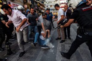 Crowd confronts police officers amid tense protests in urban area.