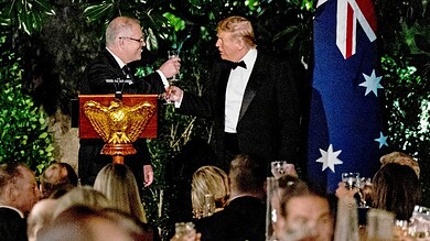 Trump and Australian leader toast at White House state dinner, lush greenery backdrop.