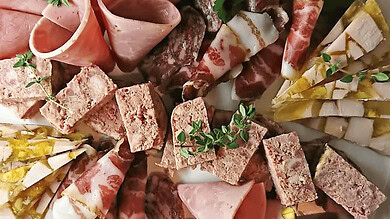 Delicious charcuterie selection featuring ham, salami, and bread slices for daily consumption.