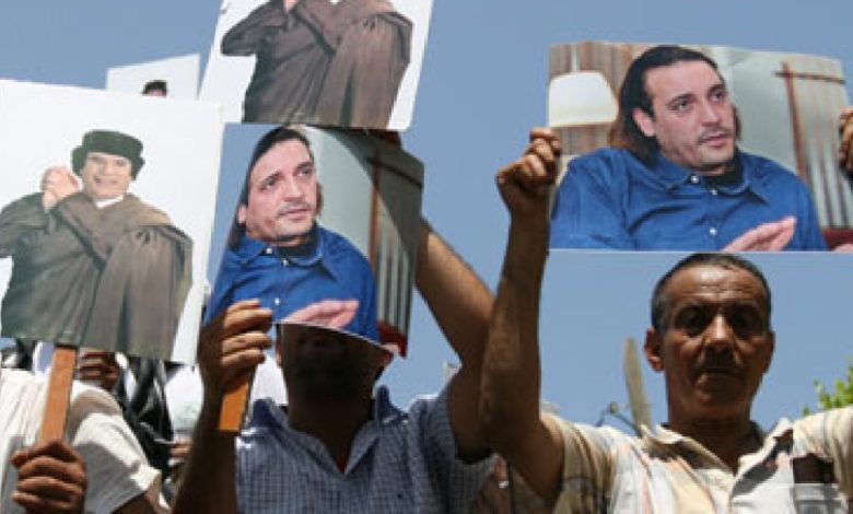 متظاهرون يرفعون صور هانيبال القذافي ووالده