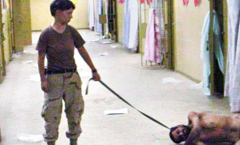 صورة حصلت عليها صحيفة واشنطن بوست ونشرت يوم 6 مايو، 2004، تظهر جندية من الجيش الأمريكي. ليندي إنغلاند، 21 عاماً، من السرية 372 للشرطة العسكرية مع معتقل عارٍ في سجن أبو غريب