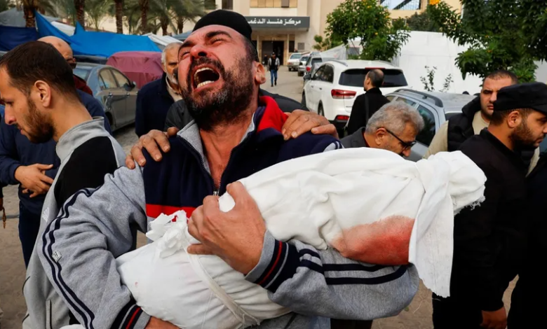 رجل فلسطيني يحمل جثمان طفلة
