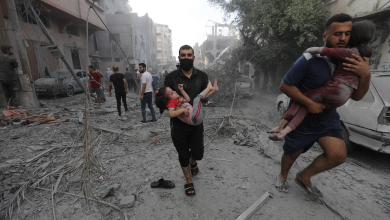 فلسطينيان يحملان طفلتين مصابتين عقب غارة إسرائيلية على قطاع غزة