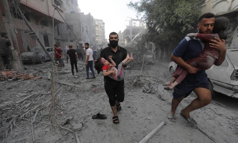 فلسطينيان يحملان طفلتين مصابتين عقب غارة إسرائيلية على قطاع غزة