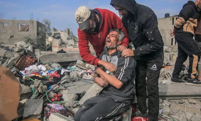 فلسطينيون أمام أنقاض منازلهم التي دمرها القصف الإسرائيلي في المغازي بوسط غزة. 26 ديسمبر 2023