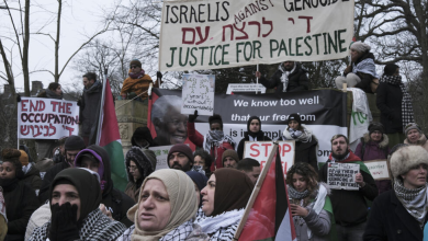 متظاهرون يحملون لافتات ويلوحون بالأعلام الفلسطينية خلال مسيرة مظاهرة خارج محكمة العدل الدولية في لاهاي، هولندا، الخميس، 11 يناير/كانون الثاني 2024