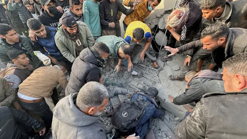 متطوعون فلسطينيون يحاولون إخراج جثامين ضحايا والبحث عن مصابين بين الأنقاض عقب غارة إسرائيلية على منزل في رفح جنوبي قطاع غزة. 24 يناير 2024