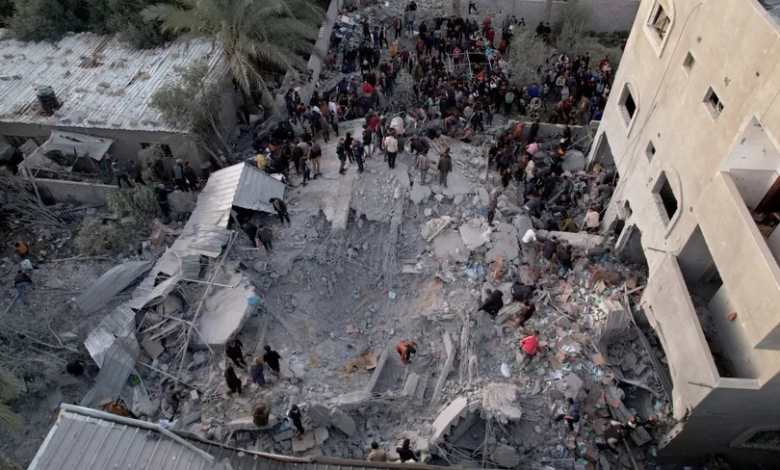 متطوعون وفرق إنقاذ يبحثون عن ضحايا أو مصابين بين أنقاض منزل دمرته غارة إسرائيلية على دير البلح في قطاع غزة. 5 يناير 2024