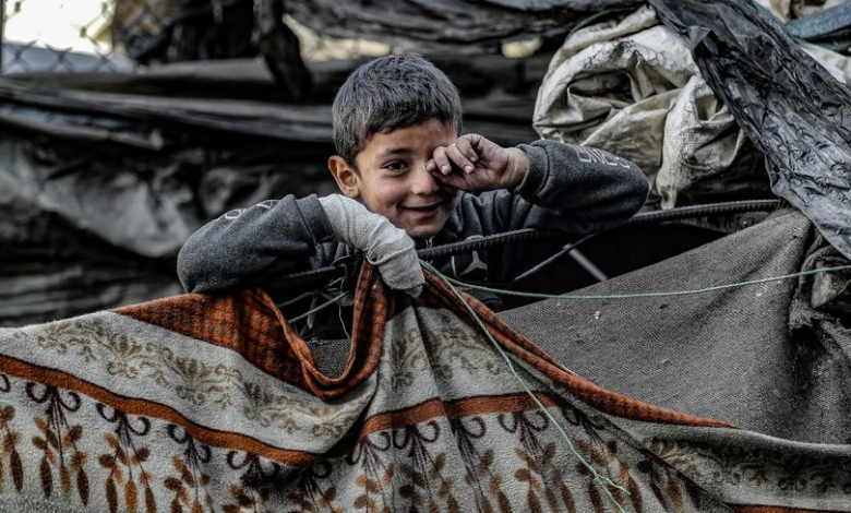 طفل فلسطيني ينتظر فيما يصطف النازحون لتلقي حصص غذائية وسط أزمة في توافر الغذاء بقطاع غزة. 5 فبراير 2024