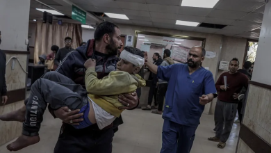 فلسطيني يحمل طفلاً مصاباً في هجمات إسرائيلية على مخيم النصيرات بقطاع غزة. 17 فبراير 2024