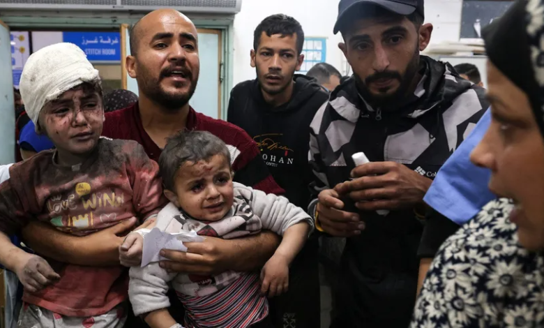 رجل يحمل أطفالاً داخل مستشفى النجار، بعدما أصيبوا في قصف إسرائيلي. رفح بجنوب قطاع غزة. 24 مارس 2024