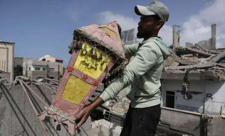 فلسطيني يحمل فانوساً ليضعه فوق منزله المدمر في دير البلح. غزة. 6 مارس 2024