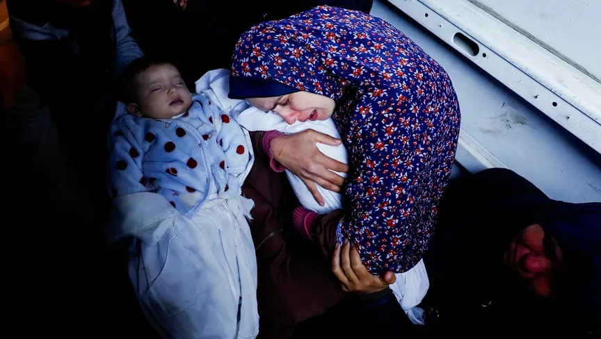 والدة التوأم الفلسطيني وسام ونعيم أبو عنزة تعانق الطفلين اللذين ولدا خلال حرب غزة وقتلتهما غارات إسرائيلية في رفح جنوب قطاع غزة. 3 مارس 2024