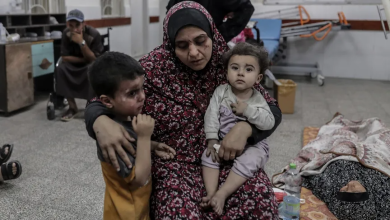 امرأة فلسطينية تحتضن طفليها الجريحين بغارة إسرائيلية، داخل مستشفى النجار في غزة. 25 أبريل 2024