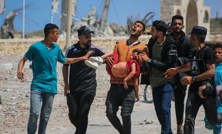 نازحون فلسطينيون يحملون طفلاً مصاباً أثناء سيرهم من وسط غزة إلى شمال القطاع. 14 أبريل 2024