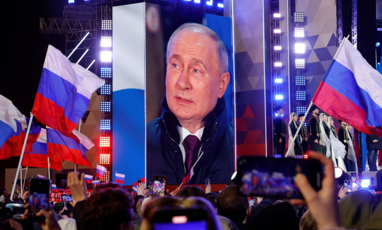 الرئيس الروسي فلاديمير بوتين الذي فاز للتو بولاية رئاسية جديدة يظهر على شاشة خلال حضوره احتفالاً وسط موسكو يوم 18 مارس 2024