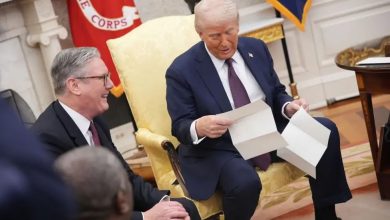 U.S. President Donald Trump holds a letter from Britain's King Charles during a meeting with British Prime Minister Keir Starmer in the Oval Office of the White House in Washington, D.C., U.S., February 27, 2025.