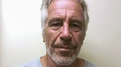 Man with gray hair and beard, looking directly at the camera, neutral expression.
