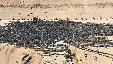 Explosion site in Libya with a large crowd of people and vehicles.